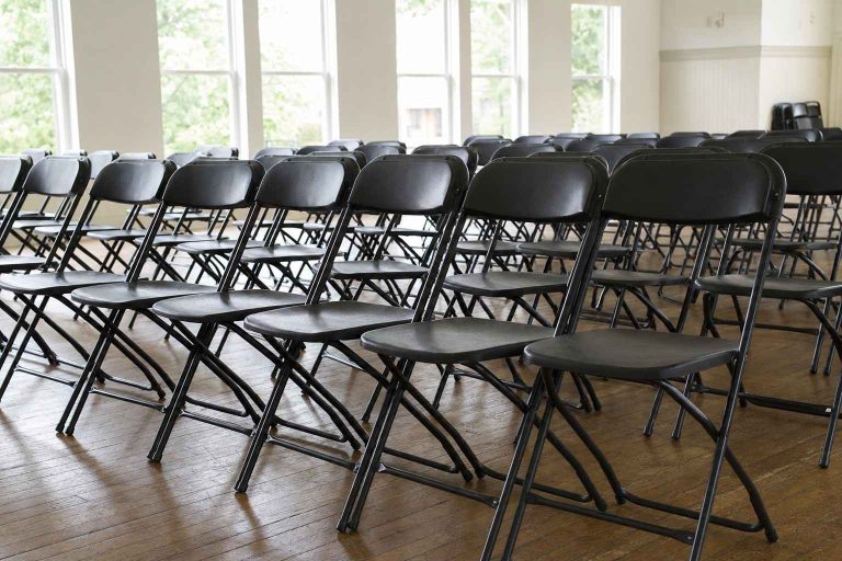 A neat row of sturdy commercial heavy-duty folding chairs set up in a bright community hall