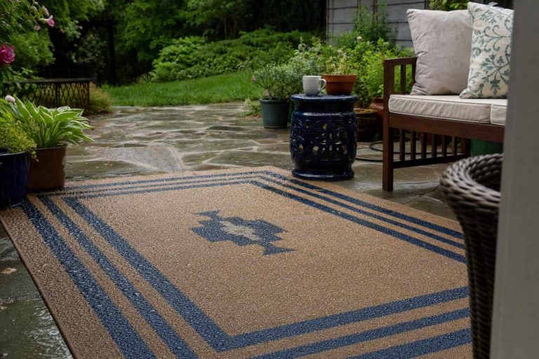An outdoor rug on a patio in light rain with water beading on the surface