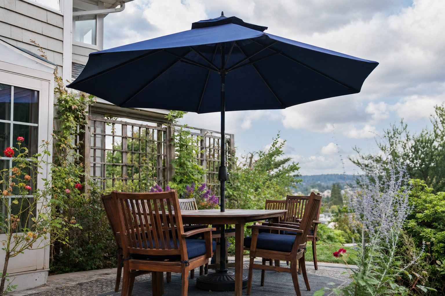 An open patio umbrella with a vented top over a patio set on a breezy day