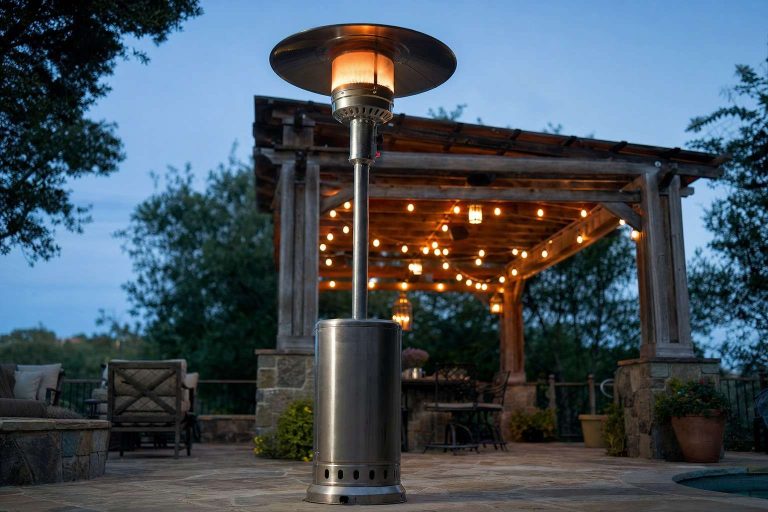 A propane mushroom patio heater standing on an evening patio