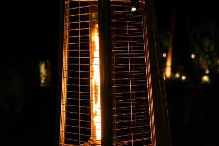 The glowing flame tube of a pyramid patio heater in the dark