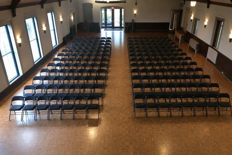 Rows of folding chairs with a center aisle seen from a high angle in an event hall