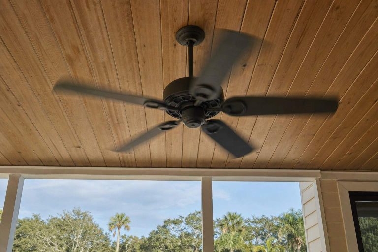 An outdoor ceiling fan mounted on a covered porch ceiling
