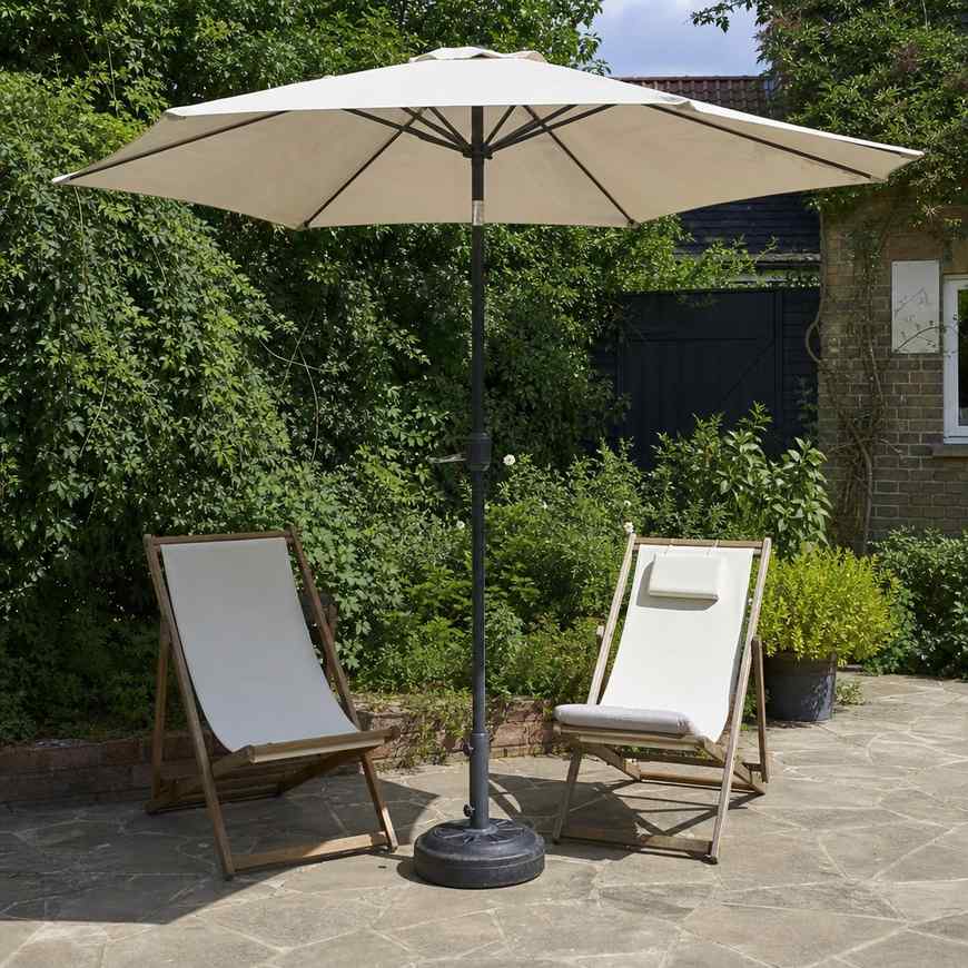 A market umbrella standing alone on a heavy round base beside two loungers